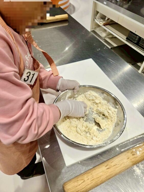 カップヌードルミュージアム大阪池田のチキンラーメンファクトリーで、子どもが粉を混ぜて麺の生地を作っている様子