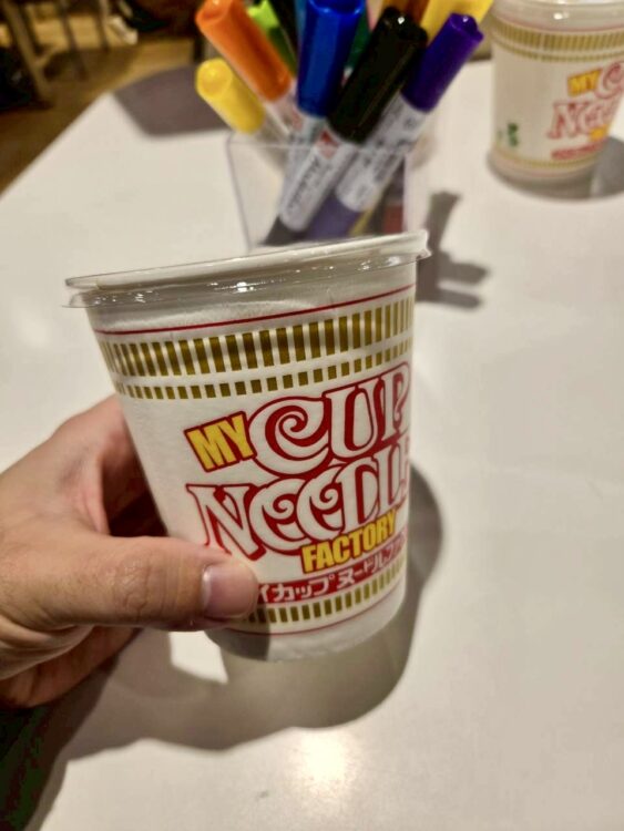 購入したマイカップヌードルのカップ。ゴミが入らないために、スタッフの方が蓋を配ってます。
