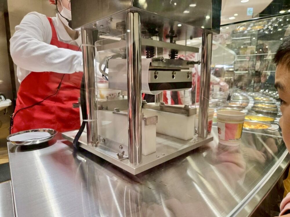 マイカップヌードルファクトリーで、カップに蓋を圧着する工程