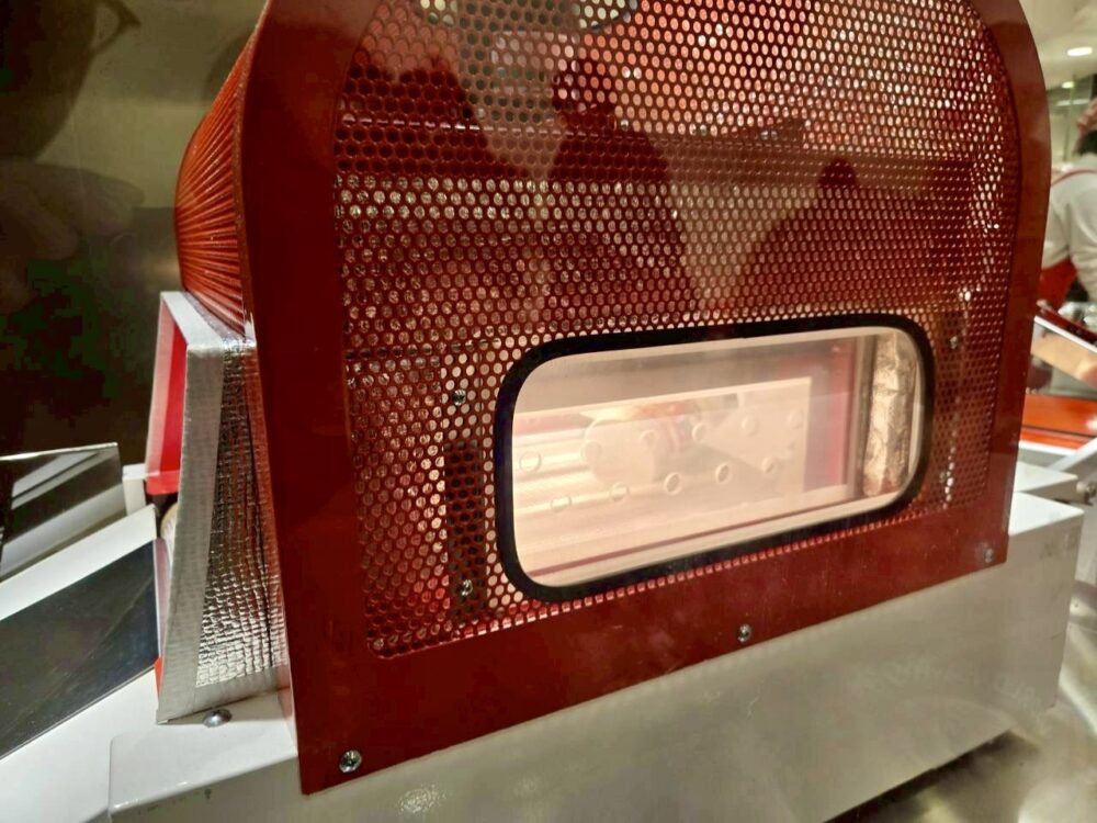 マイカップヌードルをフィルム包装し、加熱してフィルムを密着させている工程の様子