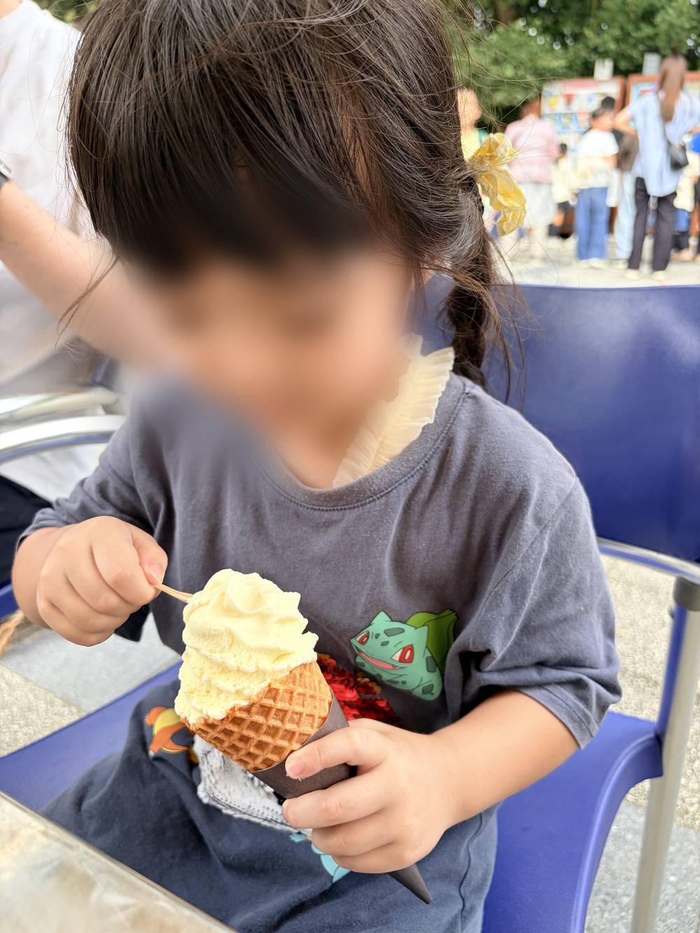 屋台で買ったソフトクリームを食べる子ども（顔はぼかしています）
